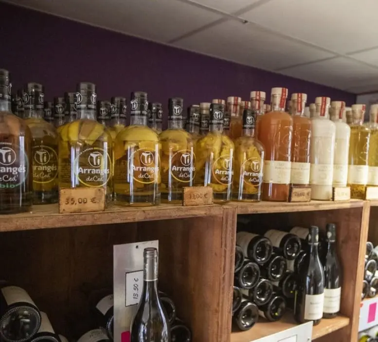 Large sélection de rhums arrangés de Ced et spiritueux artisanaux sur les étagères de la cave As du Vin à Dijon.