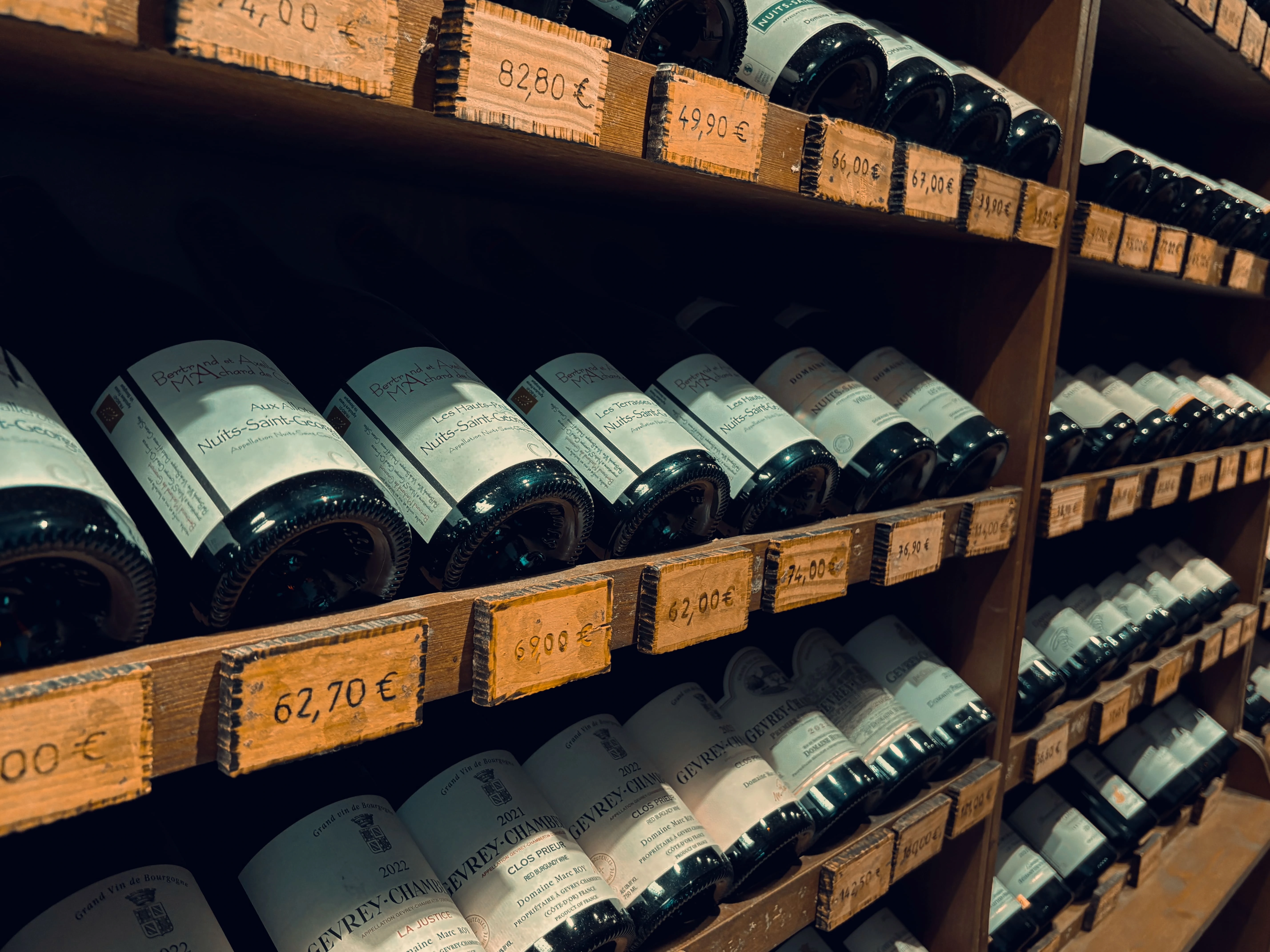 Une collection de bouteilles de vin sur une étagère de la boutique As du Vin à Dijon.
